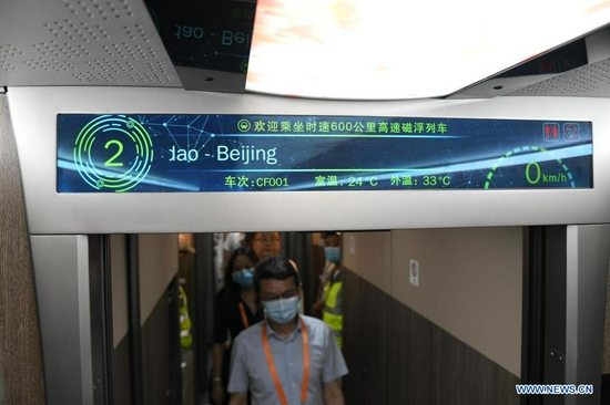 Visitors experience for themselves inside a cabinet of China's new high-speed maglev train in Qingdao, east China's Shandong Province, July 20, 2021. China's new high-speed maglev train rolled off the production line on Tuesday. It has a designed top speed of 600 km per hour -- currently the fastest ground vehicle available globally. The new maglev transportation system made its public debut in the coastal city of Qingdao, east China's Shandong Province. It has been self-developed by China, marking the country's latest scientific and technological achievement in the field of rail transit, according to the China Railway Rolling Stock Corporation. (Xinhua/Li Ziheng)