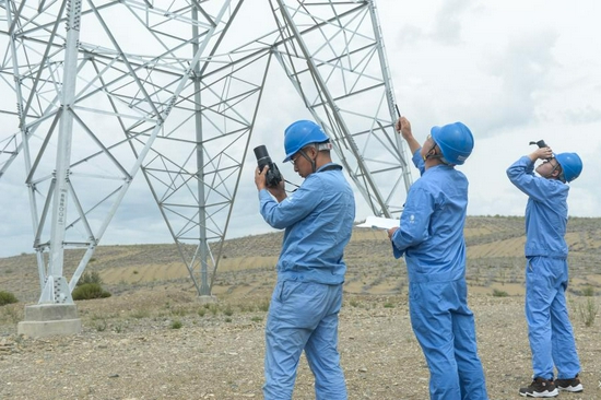 Staff members of the State Grid Corporation Qinghai Branch inspect power transmission lines in Gonghe County of Hainan Tibetan Autonomous Prefecture, northwest China's Qinghai Province, July 9, 2021. (Xinhua/Zhang Manyi)