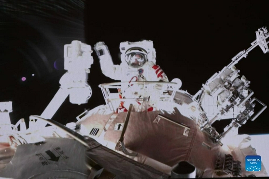 Screen image taken at Beijing Aerospace Control Center on Nov. 8, 2021 shows Chinese taikonaut Zhai Zhigang waving his hand after completing extravehicular activities (EVAs). Taikonauts Zhai Zhigang and Wang Yaping have completed their extravehicular activities (EVAs) and returned to the space station core module Tianhe, the China Manned Space Agency (CMSA) said on early hours of Monday. The pair returned to the core module at 1:16 a.m. (Beijing Time) after 6.5 hours of extravehicular activities. (Photo by Guo Zhongzheng/Xinhua)