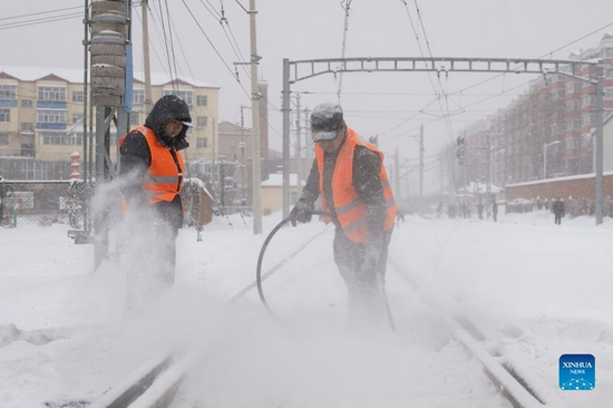 Workers of a mining company removes snow from railway tracks in Jixi City, northeast China's Heilongjiang Province, Nov. 22, 2021. Heavy snowfall hit many parts of Heilongjiang recently. Staff members of various sectors are braving frigid gusts and snowflakes to ensure normal availability of essential public services. (Xinhua/Zhang Tao) 