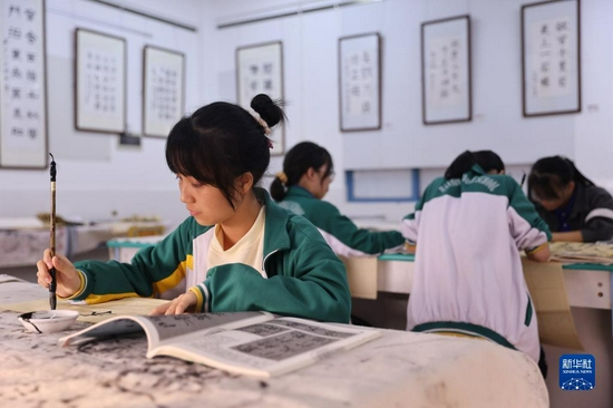 Photo shows students from Wanning Middle School, south China’s Hainan, taking part in a calligraphy class on November 24. Extra-curricular activities are tailored to childrens’ age and interests, with students having the opportunity to paticipate in arts and crafts, caligraphy and photography, among others. It is hoped that increased access to extra-curricular activities will help promote the all-round development of children. (Photo by Zhang Liyun/Xinhua)