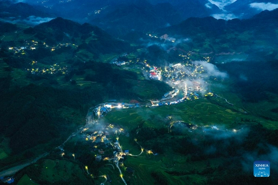 Aerial photo taken on Aug. 27, 2021 shows the night view of Gandong Village in Gandong Township of Rongshui Miao Autonomous County, south China's Guangxi Zhuang Autonomous Region. More and more solar powered street lamps have been erected in areas tucked away in the mountains in Guangxi, illuminating the night sky for people living there. (Xinhua/Huang Xiaobang) 