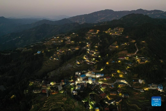 Aerial photo taken on Nov. 26, 2021 shows the night view of Dangjiu Village in Gandong Township of Rongshui Miao Autonomous County, south China's Guangxi Zhuang Autonomous Region. More and more solar powered street lamps have been erected in areas tucked away in the mountains in Guangxi, illuminating the night sky for people living there. (Xinhua/Huang Xiaobang) 