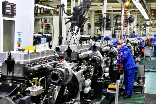 Workers assemble engines on an assembly line at a workshop of the Weichai Power Co., Ltd. in Weifang City, east China's Shandong Province, April 22, 2021. (Xinhua/Guo Xulei)