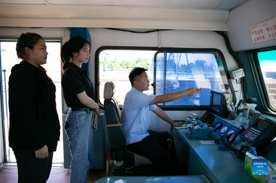 Sida Phengphongsawanh (C) learns hand gestures of train driving from a Chinese instructor at the China Railway No. 2 Engineering Group (CREC-2) railing base for the China-Laos railway, on the northern outskirts of Vientiane, capital of Laos, Sept. 12, 2021. Sida Phengphongsawanh, 22, is a trainee for China-Laos railway train driver. The China-Laos Railway, which connects Kunming in China's Yunnan Province with Lao capital Vientiane, is the first railway project built with Chinese investment, jointly operated by China and Laos and directly connected to China's railway network. While building the railway, the Laos-China Railway Co., Ltd. has opened training course for around 600 Lao trainees to learn train driving, scheduling and maintenance. Sida is one of them. 