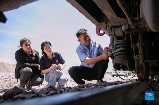 Sida Phengphongsawanh (C) learns to inspect a train from a Chinese instructor at the China Railway No. 2 Engineering Group (CREC-2) railing base for the China-Laos railway, on the northern outskirts of Vientiane, capital of Laos, Sept. 12, 2021. Sida Phengphongsawanh, 22, is a trainee for China-Laos railway train driver. The China-Laos Railway, which connects Kunming in China's Yunnan Province with Lao capital Vientiane, is the first railway project built with Chinese investment, jointly operated by China and Laos and directly connected to China's railway network. While building the railway, the Laos-China Railway Co., Ltd. has opened training course for around 600 Lao trainees to learn train driving, scheduling and maintenance. Sida is one of them. 