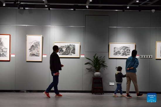 People visit the art exhibition of Wei Sancai at an art museum in Liuzhou City, south China's Guangxi Zhuang Autonomous Region, Dec. 5, 2021. An art exhibition of Wei Sancai, an art teacher, was unveiled on Friday in Liuzhou, displaying 100 art works on the theme of poverty alleviation and rural revitalization created by Wei during his tenure as a poverty alleviation official in Damiao Mountain. When he was assigned to Gaoqiang Village in Rongshui Miao Autonomous County of Liuzhou, Wei recorded the changes of the village with his paintings. In his spare time, he also took advantages of his profession to offer art classes for local children, providing them an access to the knowledge of arts. (Xinhua/Huang Xiaobang) 