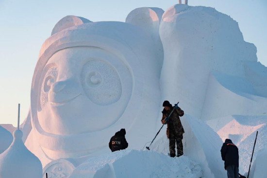 Workers finish the main snow sculpture featuring Beijing 2022 mascots at the 34th Harbin Sun Island International Snow Sculpture Art Exposition in Harbin, northeast China's Heilongjiang Province, Dec. 27, 2021. (Xinhua/Xie Jianfei)