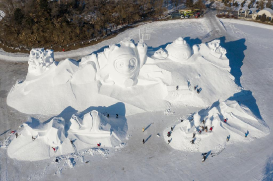 Aerial photo taken on Dec. 28, 2021 shows workers finishing the main snow sculpture featuring Beijing 2022 mascots at the 34th Harbin Sun Island International Snow Sculpture Art Exposition in Harbin, northeast China's Heilongjiang Province. (Xinhua/Xie Jianfei)