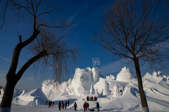 Workers finish the main snow sculpture featuring Beijing 2022 mascots at the 34th Harbin Sun Island International Snow Sculpture Art Exposition in Harbin, northeast China's Heilongjiang Province, Dec. 28, 2021. (Xinhua/Zhang Tao)