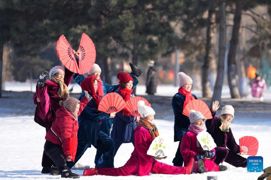 People pose for a group photo at a snow-covered park in Harbin, northeast China's Heilongjiang Province, Jan. 3, 2022. (Xinhua/Wang Jianwei)