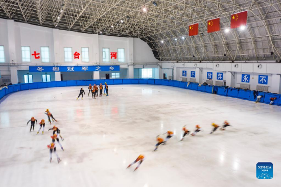 Aerial photo taken on Jan. 10, 2022 shows students of a vocational college taking part in short track speed skating training at Qitaihe Sports Center in Qitaihe City, northeast China's Heilongjiang Province. To date, six of China's 13 Winter Olympic gold medals have been claimed by athletes trained in Qitaihe City. The city has been stepping up efforts to train winter sports talents in recent years by building schools that teach short track speed skating, setting up training base for provincial sports team, as well as holding ice and snow sports events. (Xinhua/Xie Jianfei)