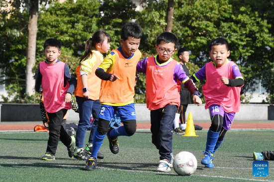Pupils play football during winter vacation in Renhuai City, southwest China's Guizhou Province, Jan. 18, 2022. (Photo by Chen Yong/Xinhua)