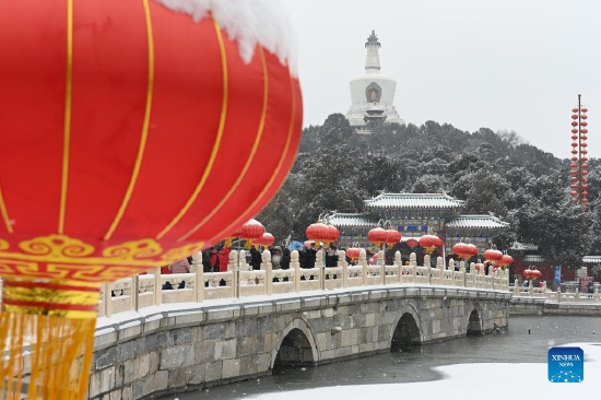 People enjoy the snow view at Beihai Park in Beijing, capital of China, Feb. 13, 2022. A snowfall hit Beijing on Sunday. (Xinhua/Song Weiwei)