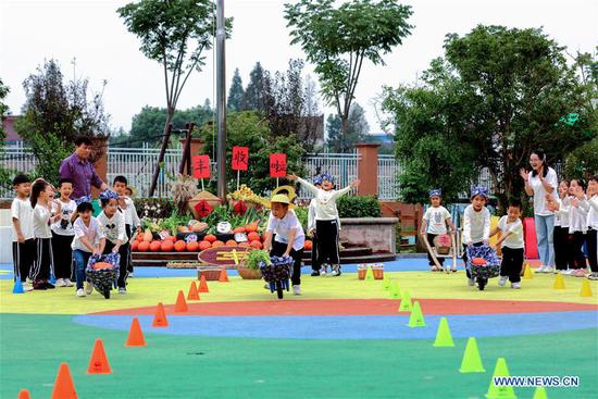 Children take part in a crops transporting competition during an event held ahead of farmers' harvest festival in Changxing, east China's Zhejiang Province, Sept. 21, 2020. The third Chinese farmers' harvest festival falls on Sept. 22, 2020. (Xinhua/Xu Yu)