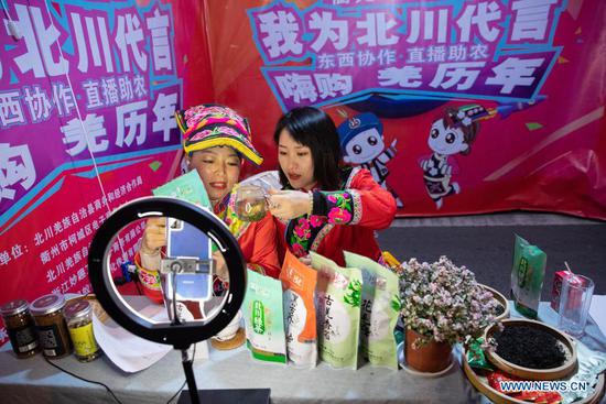 Farmers in ethnic Qiang costume sell local products via livestream in Beichuan County, southwest China's Sichuan Province, Nov. 14, 2020. A live streaming event featuring poverty alleviation products was inaugurated here Saturday and lasts until Nov. 16. About 17,000 orders worth two million yuan (302,800 U.S. dollars) were reached during the two-hour livestream on Saturday. (Xinhua/Jiang Hongjing)