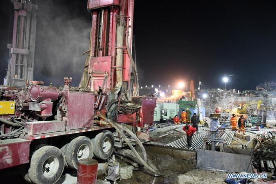 Rescuers drill a new channel at the explosion site of a gold mine in Qixia City, east China's Shandong Province, Jan. 18, 2021. A new channel has been drilled to rescue the workers trapped by a gold mine blast in east China's Shandong Province, authorities said early Monday. The channel, drilled through at around 5 a.m., reaches a section 698 meters from the mine entrance. It came after another channel was drilled Sunday at a section 648 meters from the entrance. Rescuers knocked on the drilling pipe, but have not yet received responses, according to the rescue headquarters. The blast took place at 2 p.m. on Jan. 10 at the gold mine in Qixia under Yantai City. It happened about 240 meters away from the entrance. Twenty-two workers were working more than 600 meters away from there. On late Sunday, a paper slip retrieved from underneath the mine through the previously drilled channel said that 12 workers were still alive while the other 10 were in unclear situations. (Xinhua/Wang Kai)