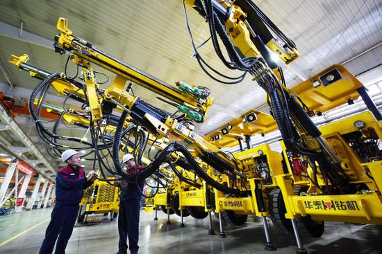 Workers of Zhangjiakou Xunhua Huatai Mining and Metallurgical Machinery Co., Ltd. in north China’s Hebei province check drilling machines, Dec. 19, 2020. (People’s Daily Online/Chen Xiaodong)