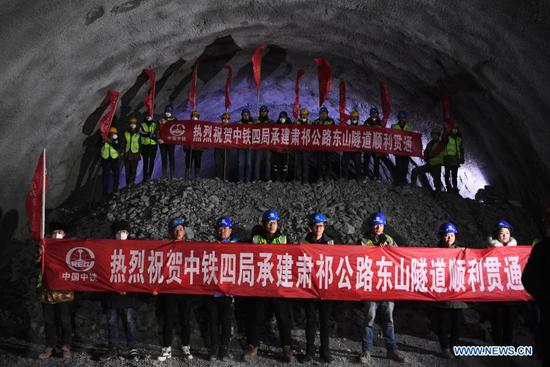 Workers of the China Railway No.4 Engineering Group celebrate the drill-through of the Dongshan tunnel along the national highway No. 213 in Yugur Autonomous County of Sunan of northwest China's Gansu Province, on March 2, 2021. The 3,639-meter Dongshan tunnel at an average altitude of 3,850 meters was drilled through on Tuesday. It is a critical project for national highway No. 213 that connects Sunan to Qilian County in Qinghai Province, also in northwest China. (Xinhua/Chen Bin)