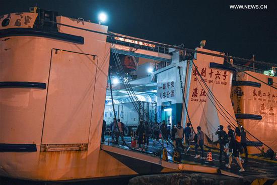 Passengers board a roll-on roll-off ship at Xiuying Port in Haikou, south China's Hainan Province, Oct. 29, 2020. Ferry services across the Qiongzhou Strait have partially resumed from 4:00 p.m. Thursday as Typhoon Molave, the 18th this year, weakened. (Xinhua/Pu Xiaoxu) 
