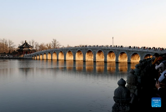 Photo taken on Nov. 25, 2021 shows the sunset illuminating the arches of the 17-Arch Bridge in the Summer Palace in Beijing, capital of China. (Xinhua/Chen Jianli) 