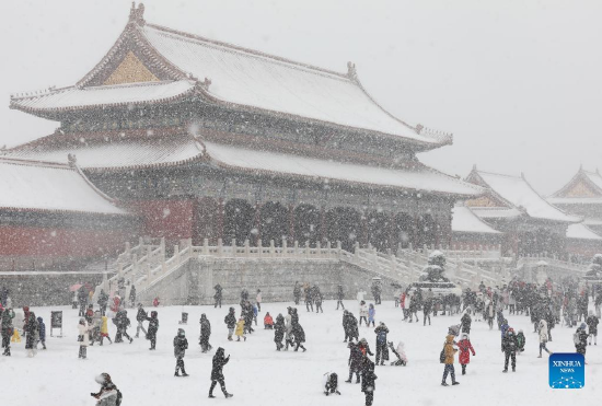 People enjoy the snow view at the Palace Museum, also known as the Forbidden City, in Beijing, capital of China, Feb. 13, 2022. A snowfall hit Beijing on Sunday. (Xinhua/Jin Liwang)
