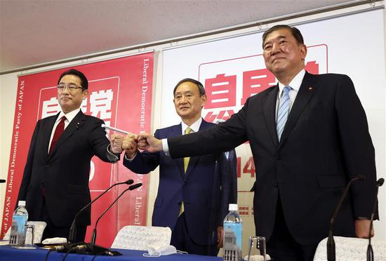 Japan’s ruling Liberal Democratic Party leadership candidates — Chief Cabinet Secretary Yoshihide Suga (center), former defense minister Shigeru Ishiba (right) and former foreign minister Fumio Kishida — pose for photographs at the LDP headquarters in Tokyo.