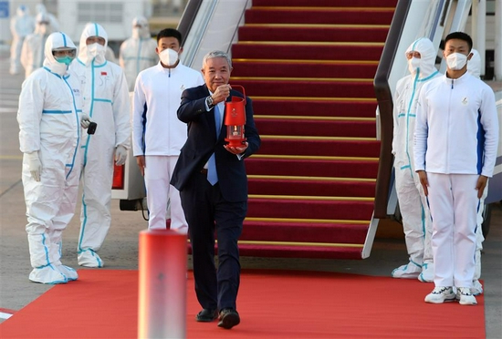 Special representative and Vice-President of Beijing 2022 Yu Zaiqing holds up a lantern containing the Olympic Fame after arriving in Beijing on October 20, 2021.