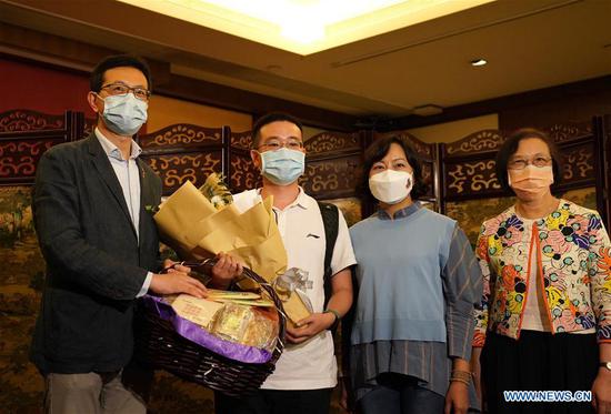 Guo Penghao (2nd L), leader of a team of seven virus testing professionals from the Chinese mainland, receives a bouquet from a representative of local residents in Hong Kong, south China, Aug. 2, 2020. Seven virus testing professionals from the Chinese mainland arrived in Hong Kong on Sunday afternoon as the first batch of mainland supportive teams to help contain a worsening spread of COVID-19 in Hong Kong. (Xinhua/Li Gang)