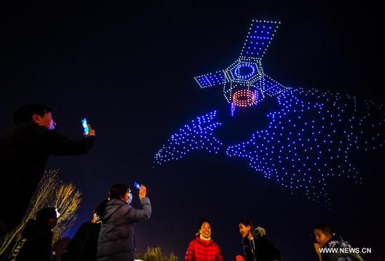 Citizens view a drone light display at a park in Changchun, northeast China's Jilin Province, Oct. 14, 2020. A light display featuring 1,000 drones was held on Wednesday as a part of the 2020 Changchun International UAV Industrial Expo. The light display will be held every night from Oct. 14 to 16. (Xinhua/Yan Linyun)