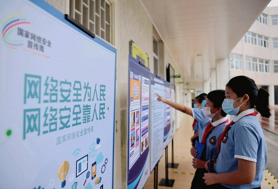 Pupils of Caochang Street Primary School watch billboards on cyber security in Qiaoxi District of Shijiazhuang, capital of north China's Hebei Province, Sept. 14, 2020. (Xinhua/Wang Xiao)