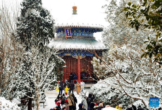 Photo taken with a mobile phone shows people visiting Jingshan Park in Beijing, capital of China, Feb. 13, 2022. A snowfall hit Beijing on Sunday. (Xinhua/Pan Xu)