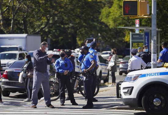 Police officers stand guard in a COVID-19 hotspot area of Queens in New York, the United States, on Oct. 8, 2020. (Xinhua/Wang Ying)