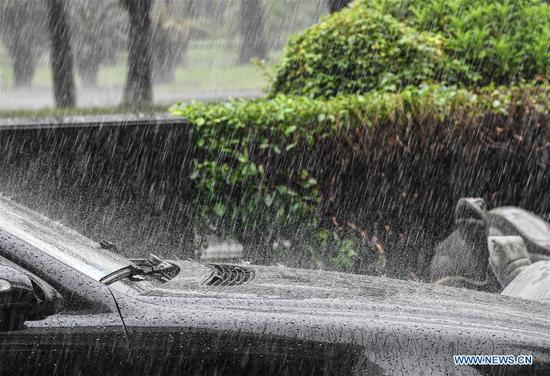 A car is pictured in the rain in Haikou, south China's Hainan Province, Oct. 28, 2020. Molave weakened from a super typhoon to typhoon on Wednesday morning, bringing rainstorms to the island province of Hainan in south China, the local weather bureau said. (Xinhua/Pu Xiaoxu)