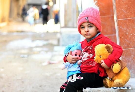 A girl plays with her toys near her house in Damascus, Syria on Nov. 18, 2020. The globe will mark this year's World Children's Day on Friday. (Photo by Ammar Safarjalani/Xinhua)