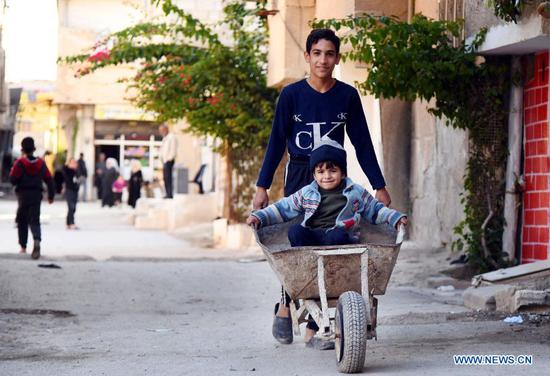 Children play near their house in Damascus, Syria on Nov. 18, 2020. The globe will mark this year's World Children's Day on Friday. (Photo by Ammar Safarjalani/Xinhua)