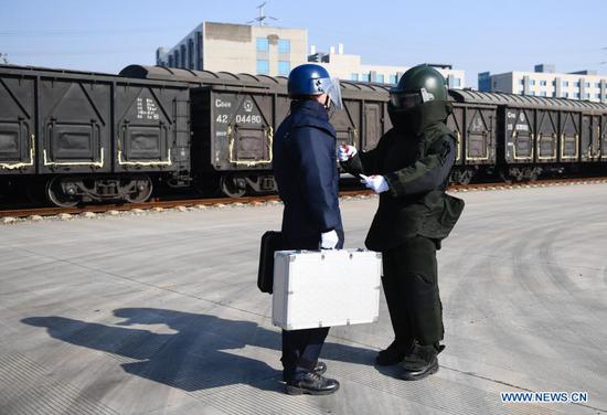 Bomb disposal team members exchange information as they handle 