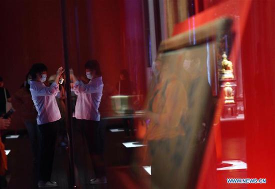 A visitor takes photos of exhibits during an exhibition entitled 