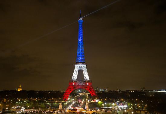 The Eiffel Tower is lit with the blue, white and red colours of the French flag in Paris, France, Nov. 16, 2015, to pay tribute to the victims of the terror attacks on Nov. 13, 2015, in the French capital. (Xinhua/Xu Jinquan)