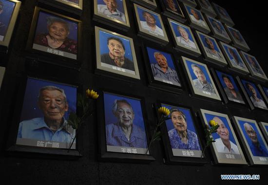The lights representing Chen Guangshun, Wang Xiuying and Zhao Jinhua (1st L to 3rd L in the bottom row) on a wall commemorating Nanjing Massacre survivors are turned off, signaling their passing, at the Memorial Hall of the Victims in Nanjing Massacre by Japanese Invaders in Nanjing, capital of east China's Jiangsu Province, Dec. 6, 2018. A total of 20 survivors have passed away this year, according to the Memorial Hall. The Nanjing Massacre took place when Japanese troops captured the city on Dec. 13, 1937. Over six weeks, they killed 300,000 Chinese civilians and unarmed soldiers. The survivors are living witnesses of the massacre. However, there are now less than 100 registered survivors, official data showed. (Xinhua/Sun Can)