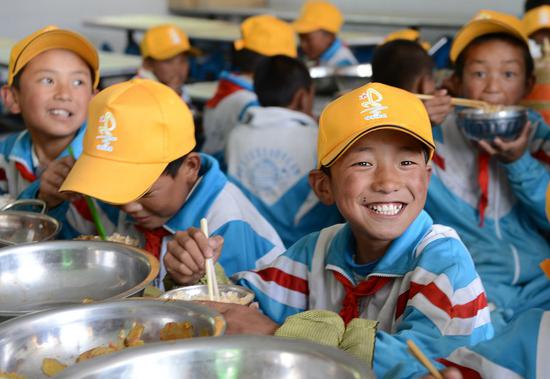 File photo shows students of Wanquan Primary School eating lunch at school in Pozhang Township of Shannan, southwest China's Tibet Autonomous Region. (Xinhua/Chogo)