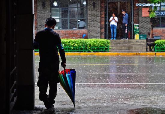 A pedestrian takes shelter from a downpour in Benxi, northeast China's Liaoning Province, Aug. 27, 2020. Typhoon Bavi, the eighth of this year, brought gales and rainstorms to cities in northeast China. (Photo by Lin Lin/Xinhua) 