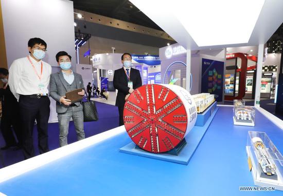 Visitors view tunnel boring machine models during the 8th China (Shanghai) International Technology Fair (CSITF) in east China's Shanghai, April 15, 2021. The 8th CSITF kicked off on Thursday. With an exhibition area covering 35,000 square meters, this year's fair has 5 different sections and has attracted over 1,000 exhibitors. (Xinhua/Fang Zhe)