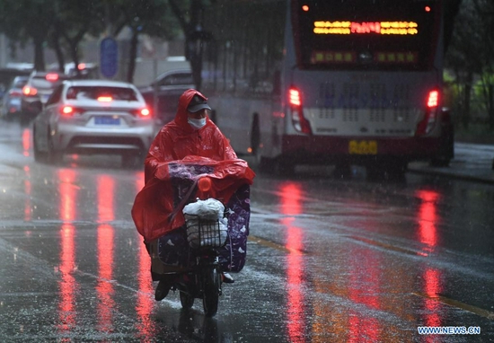 A citizen rides in rain on a street in Haidian District of Beijing, capital of China, July 12, 2021. Heavy rainstorm has lashed the Chinese capital Beijing since 6 p.m. Sunday with precipitation up to 116.4 mm, according to the municipal flood control department. From 6 p.m. Sunday to 9 a.m. Monday, Beijing registered average rainfall of 65.9 mm. Urban areas of the city reported higher average precipitation of 79.9 mm. (Xinhua/Ren Chao)