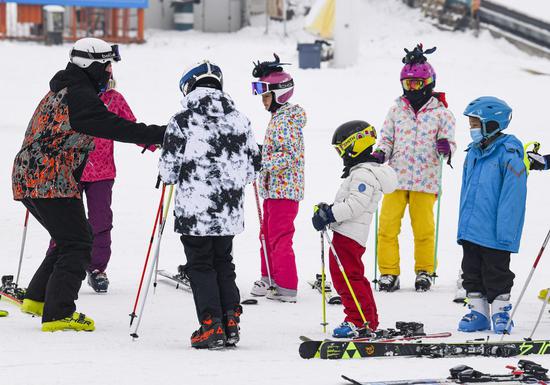 Children are guided to ski at Silkroad Resort in Urumqi, northwest China's Xinjiang Uygur Autonomous Region, Feb. 12, 2020. TO GO WITH "Countdown to Beijing 2022: Winter sports boom for children during holiday season in NW China" (Xinhua/Wang Fei)