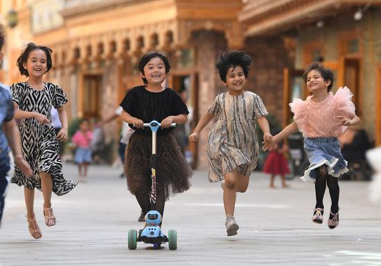 Children have fun on Dove Lane in Hotan City, northwest China's Xinjiang Uygur Autonomous Region, May 27, 2020. (Xinhua/Sadat)