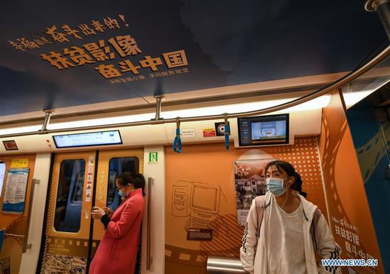 Passengers take a poverty-alleviation-themed train of the Line 1 of Chengdu Metro in Chengdu, southwest China's Sichuan Province, Oct. 17, 2020. China marked the seventh National Poverty Relief Day on Saturday. A poverty-alleviation-themed train, with photos and videos displaying poverty alleviation achievements in Sichuan, made its first running on the Line 1 of Chengdu Metro on Saturday. The train will run till the end of this year. (Xinhua/Wang Xi)