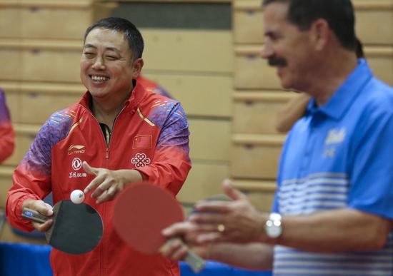 Liu Guoliang (L), president of the Chinese Table Tennis Association, serves the ball during a joint training session between the Chinese and U.S. national table tennis teams in Orange County, California, the United States, Aug. 17, 2019. (Xinhua/Li Ying)