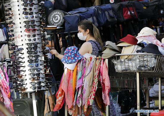 A woman wearing a mask shops at a store in Ankara, Turkey, on Aug. 3, 2020. Turkey reported 995 new COVID-19 cases on Monday, raising the total diagnosed cases to 233,851, Turkish Health Minister Fahrettin Koca said. (Photo by Mustafa Kaya/Xinhua)