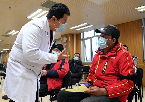 A medical worker (1st L) inquires a recipient of his physical condition after receiving a COVID-19 vaccine shot at a temporary inoculation site in Haidian District in Beijing, capital of China, Jan. 11, 2021. (Xinhua/Ren Chao)